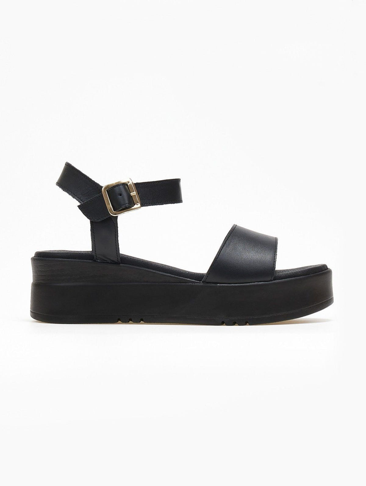 Black leather flatform sandal with wide front strap and gold ankle buckle, side view