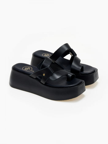 Black leather platform slide sandals with crossover toe loop straps, three-quarter view