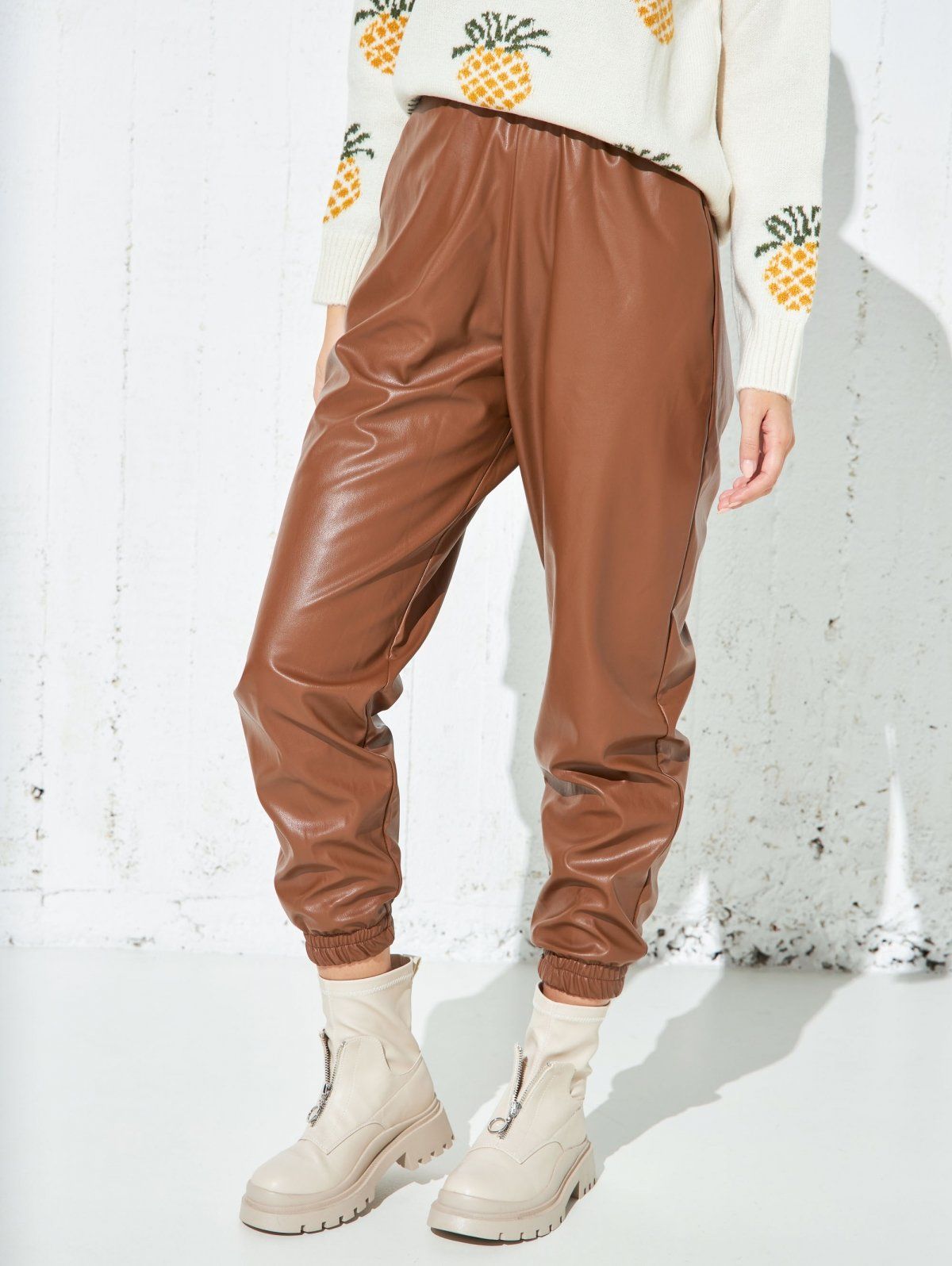 Brown faux leather jogger pants with elasticated waist and gathered elastic ankle cuffs, relaxed fit, worn on model, front view