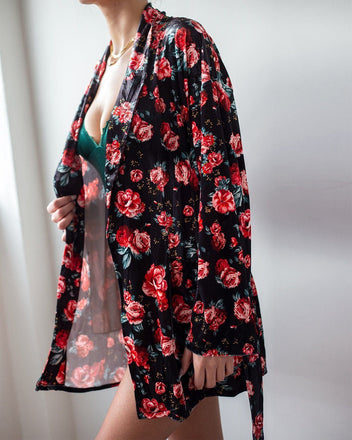 Black velvet robe with red rose floral print and open front with long belt, worn on model, side view