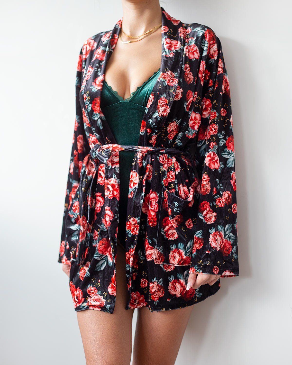 Black velvet robe with red rose floral print, kimono sleeves and belt tied at the waist, worn on model, front view