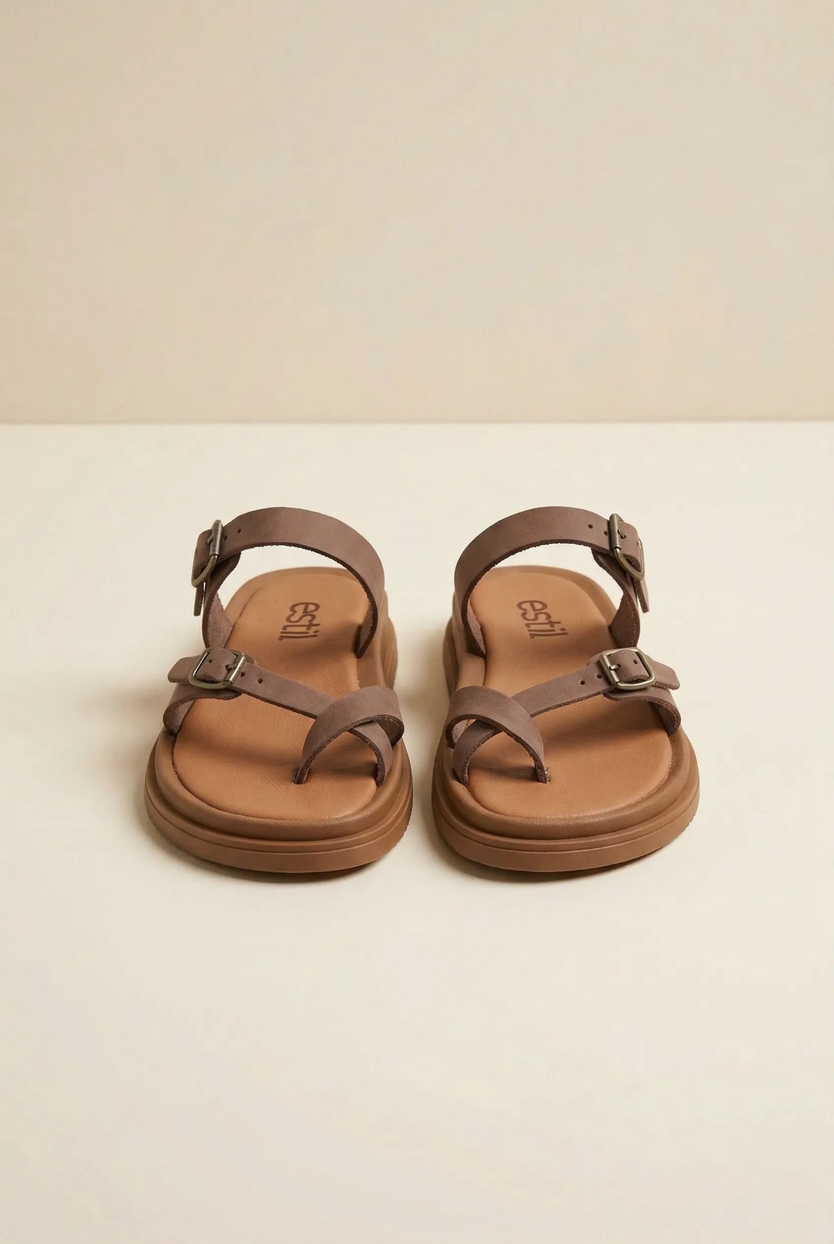 Pair of brown nubuck leather sandals with toe loop, two buckled straps, ankle strap and cushioned footbed, front view
