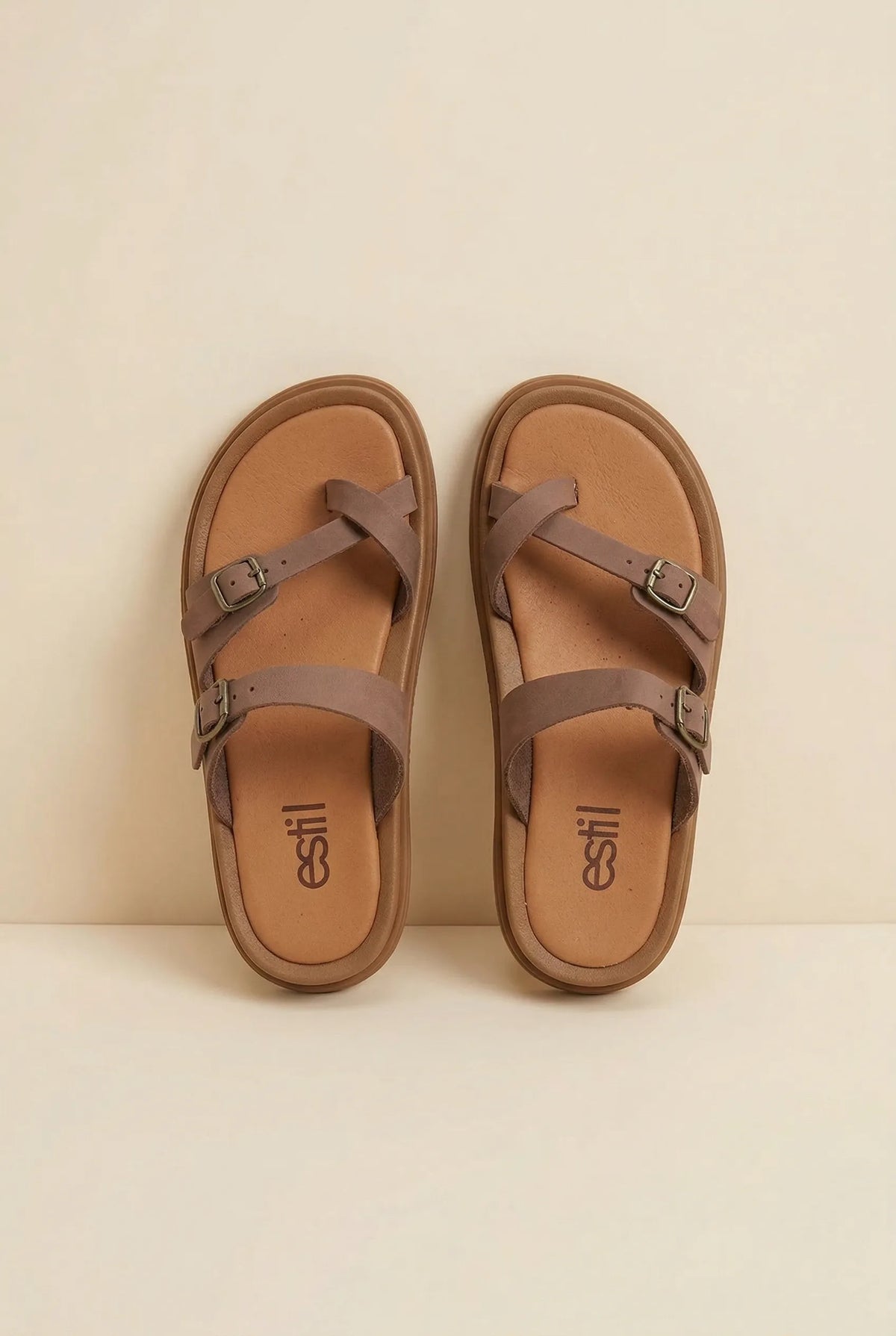 Pair of brown leather toe-loop slide sandals with buckled straps and tan padded footbeds, top-down view