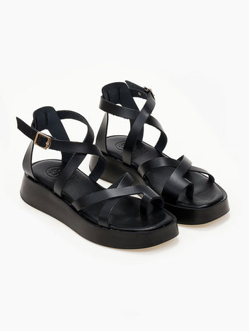 Black leather crossover strap platform sandals with toe loop and ankle buckle, three-quarter view
