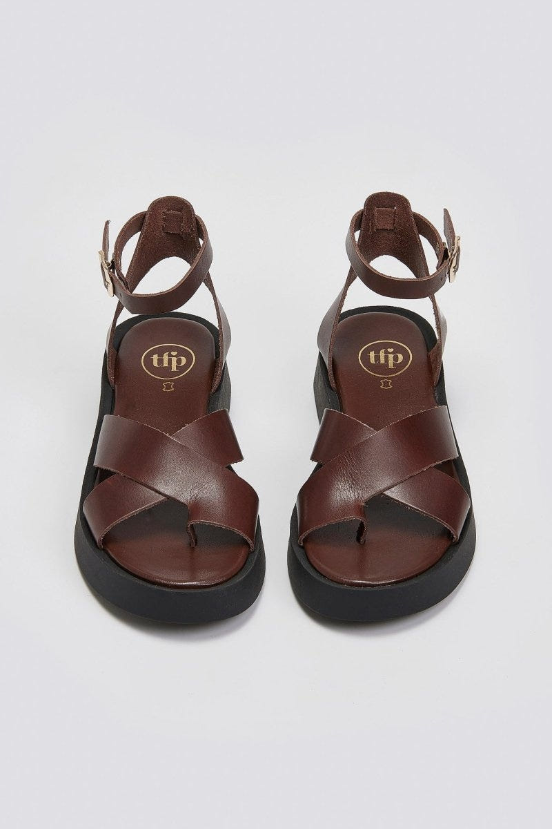 Pair of brown leather crossover strap platform sandals with ankle strap and black sole, top view