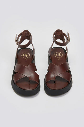 Pair of brown leather crossover strap platform sandals with ankle strap and black sole, top view