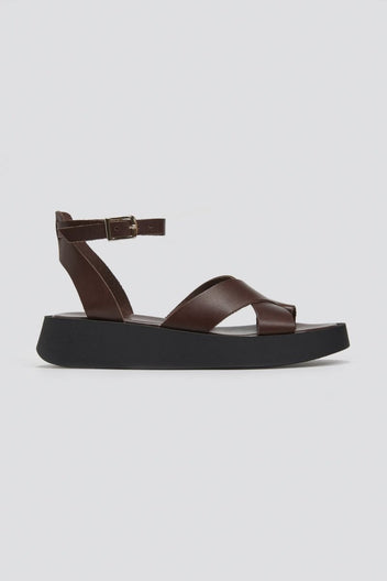 Brown leather crossover strap platform sandal with ankle strap and black sole, side view