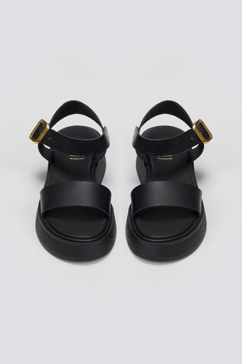 Pair of black leather platform sandals with wide front strap and gold ankle buckle, front view