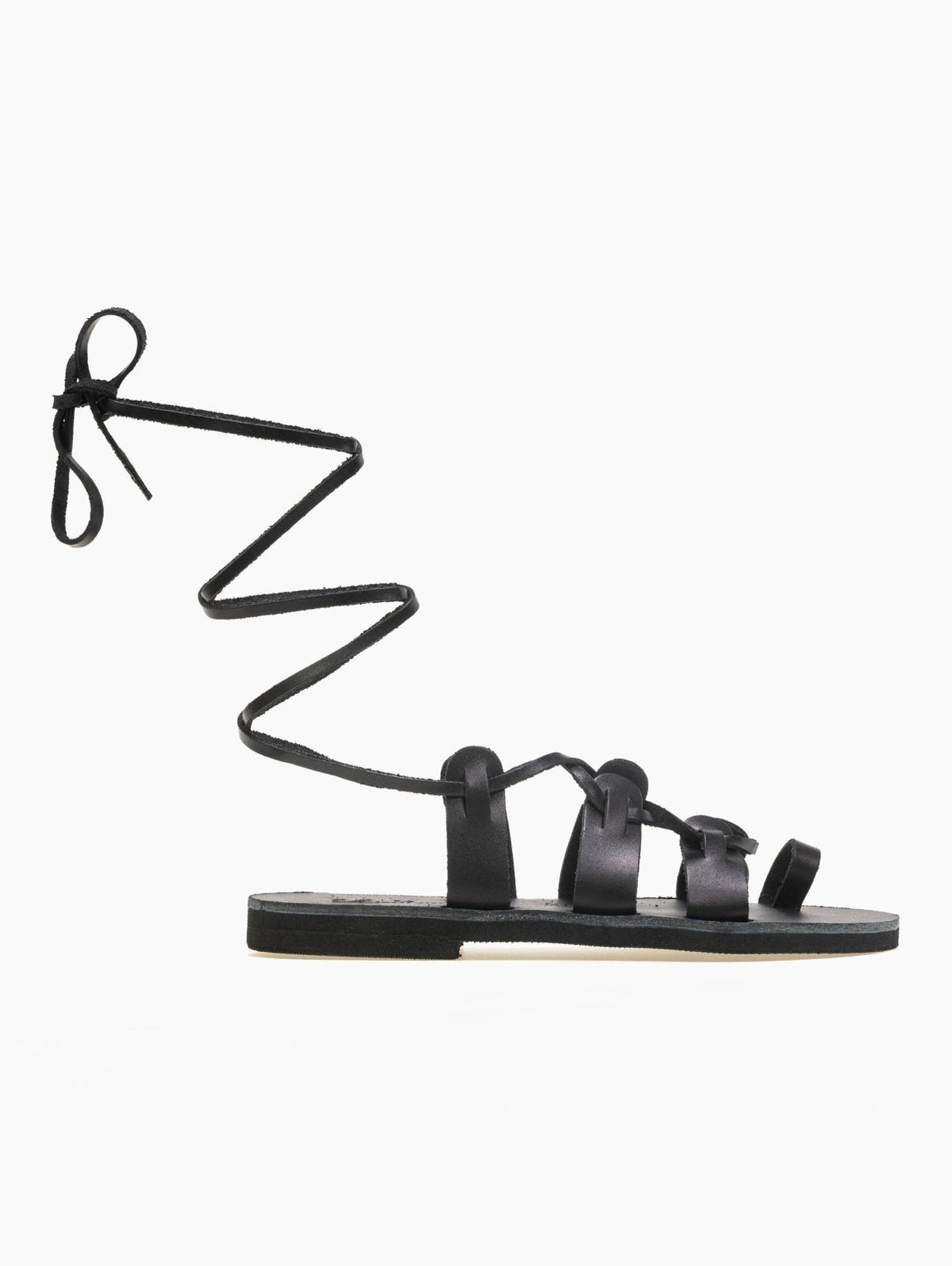 Black leather lace-up flat sandal with toe loop and long ankle ties, side profile view
