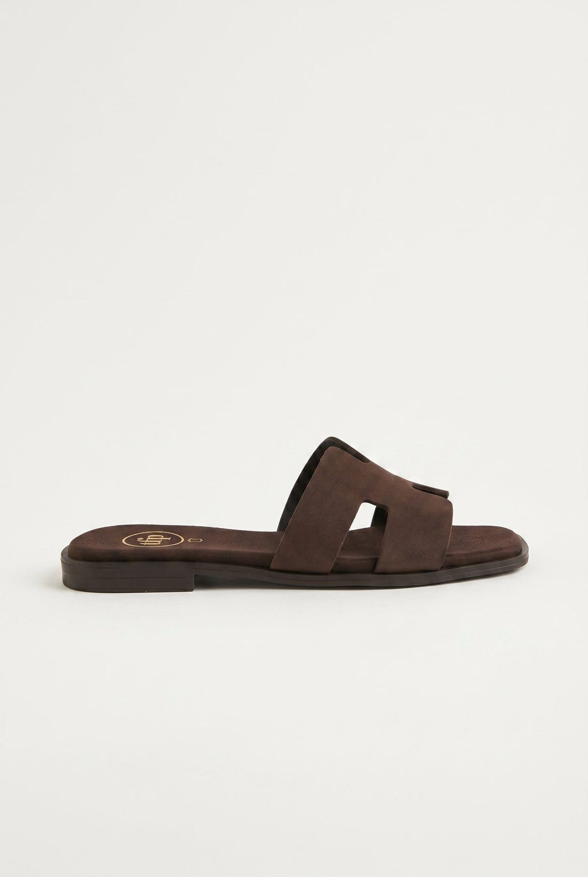 Dark brown suede cut-out H strap flat slide sandal with square toe, side profile view of the sole