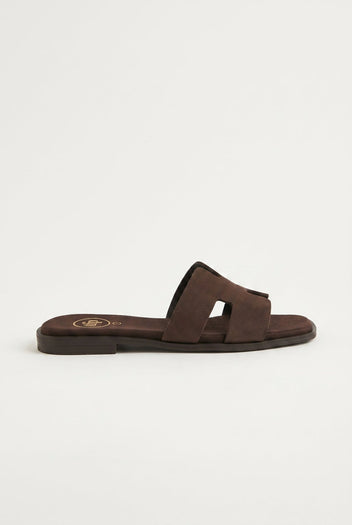 Dark brown suede cut-out H strap flat slide sandal with square toe, side profile view of the sole