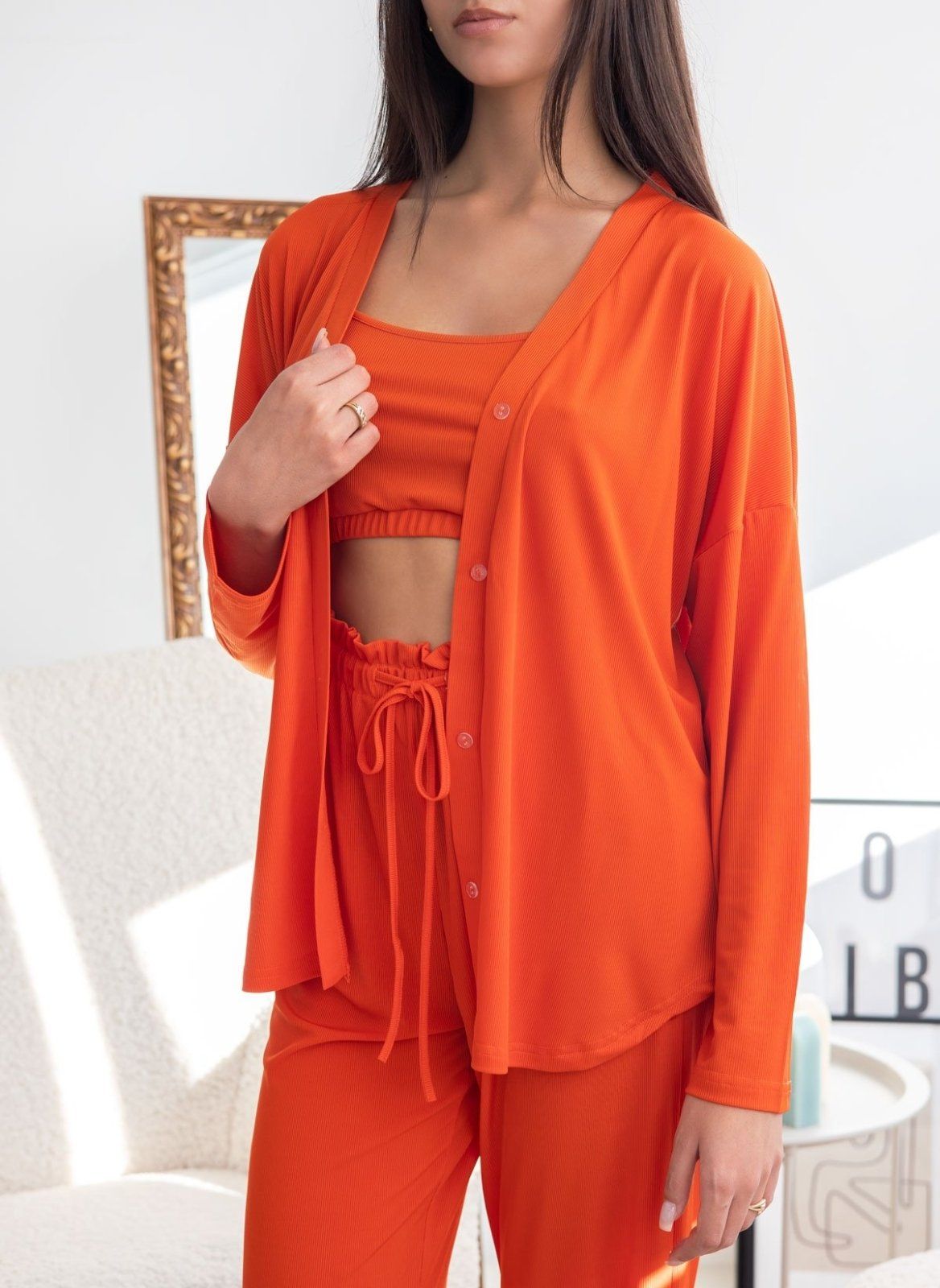 Orange ribbed pyjama long-sleeve button shirt over camisole top and gathered drawstring waist, worn on model, front view