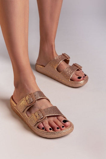 Model wearing rose gold glitter double buckle slide sandals with beige footbed, front view of feet