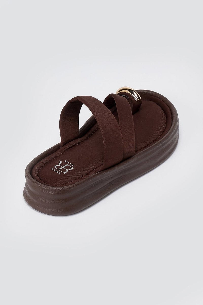 Single brown flatform sandal seen from above at an angle, with a wide cushioned strap and thick ridged platform sole