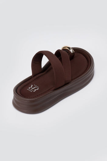 Single brown flatform sandal seen from above at an angle, with a wide cushioned strap and thick ridged platform sole