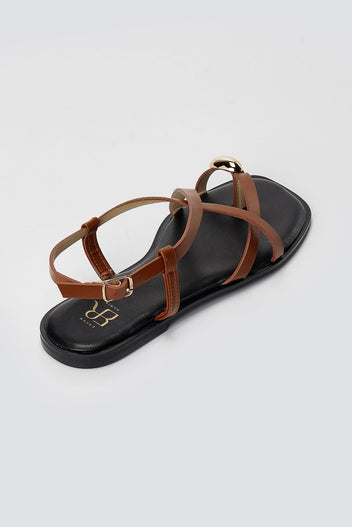 Single tan leather toe ring sandal from above, showing crossed straps, ankle buckle and a black padded footbed